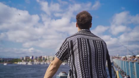 El-Joven-Está-Mirando-El-Cielo-Contra-El-Mar-En-Estambul.